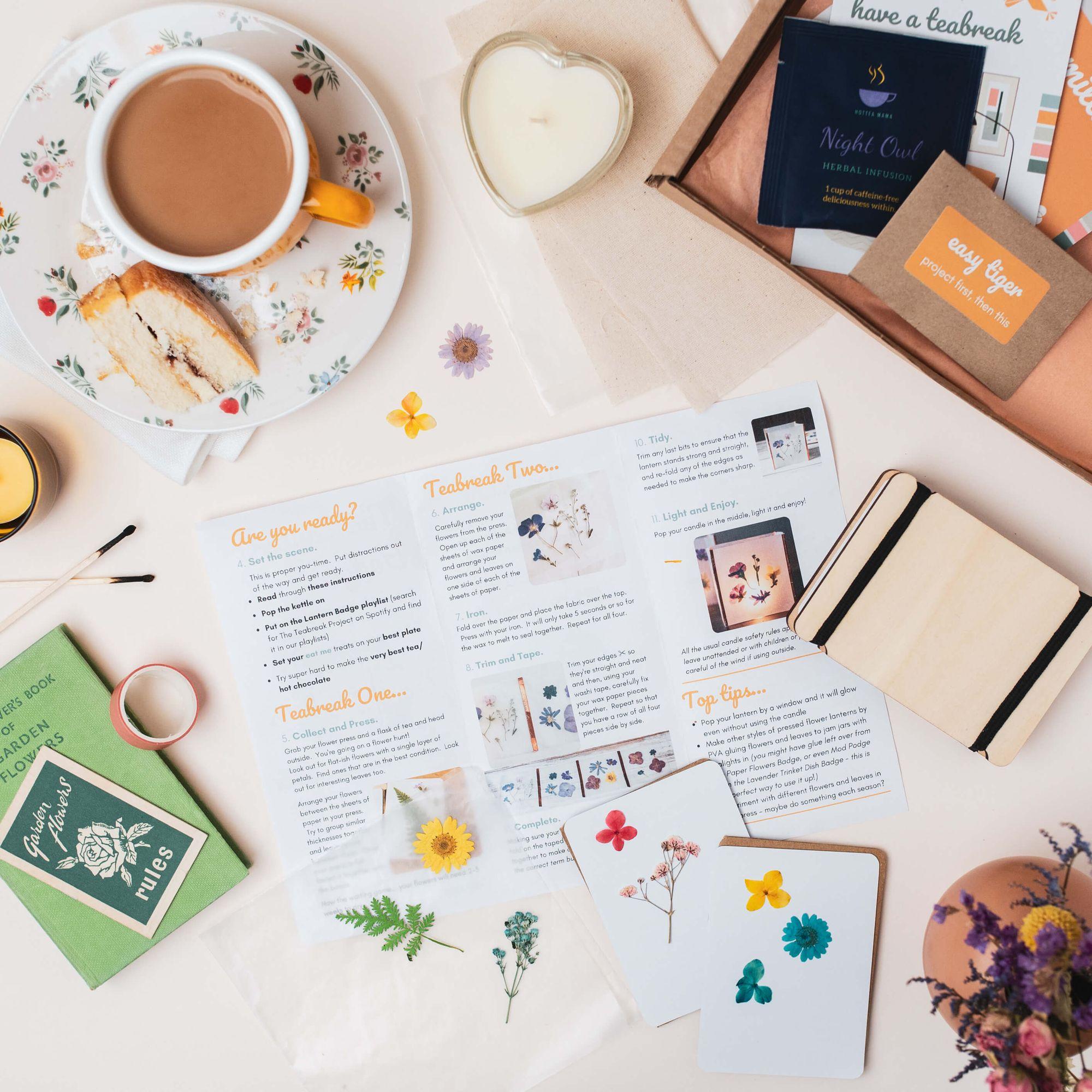 A Teabreak laid out on a table with tea, cake, a lit tealight and a creative project part-finished