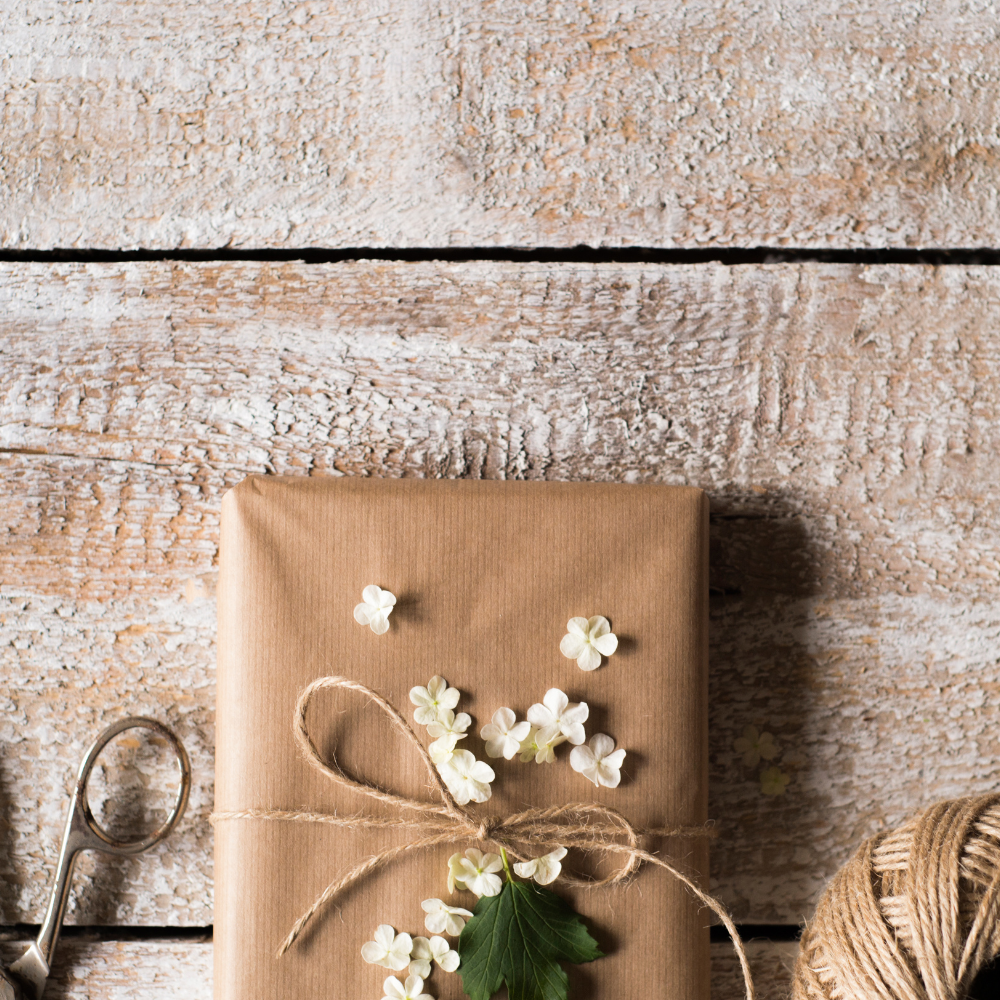 A beautifully wrapped mystery parcel tied with twine and scattered with tiny white flowers, waiting to be opened